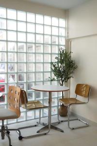 a table and chairs in front of a large window at Yimwhan House 02, Ayutthaya old town in Phra Nakhon Si Ayutthaya