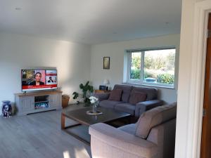 a living room with a couch and a tv at The Bungalow, Forest of Dean in Coleford