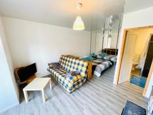 a living room with a couch and a bed and a mirror at Résidence Le Clos Saint-Savin in Font-Romeu-Odeillo-Via