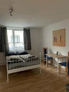 Schlafzimmer mit einem Bett, einem Schreibtisch und einem Tisch in der Unterkunft Schönes einfaches Zimmer im belebten Zentrum in Wilhelmshaven