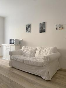 a white couch sitting in a living room at WoodenKey Asiago grazioso appartamento in centro in Asiago