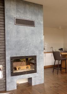 a stone fireplace in a living room with a chair at Domki Blisko Nieba I in Wisła