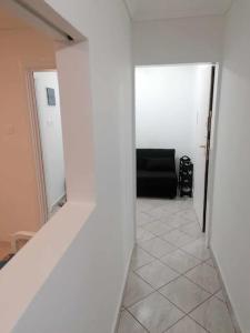 - un couloir avec un canapé noir dans la chambre dans l'établissement Κουκλόσπιτο, à Thessalonique