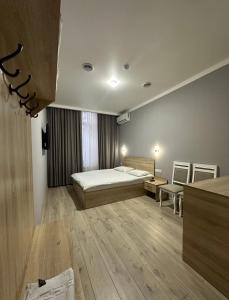 une chambre avec un lit et une chaise dans une pièce dans l'établissement Holiday house Bishkek, à Bishkek
