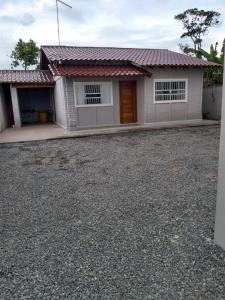 una casa con una entrada de grava delante de ella en Casa e conforto en Itapoa
