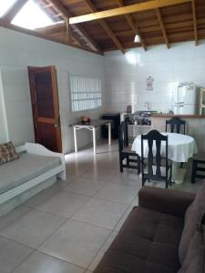 sala de estar con mesa y cocina en Casa e conforto en Itapoa