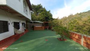 圣希尔Hospedaje Campestre Villa Niny的绿色地板和庭院的房子