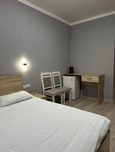 une chambre avec un lit, un bureau et une chaise dans l'établissement Holiday house Bishkek, à Bishkek