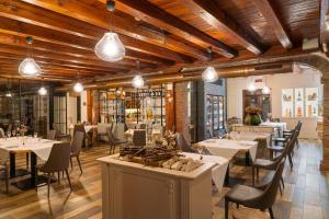 a restaurant with white tables and chairs and lights at Hotel Alla Corte SPA & Wellness Relax in Bassano del Grappa