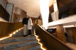 um homem e uma mulher em pé nas escadas de um edifício em Hotel Splendid em Madonna di Campiglio