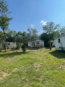 a view of a campsite with a caravan and trees at Camping Beaussement TWENTY in Chauzon