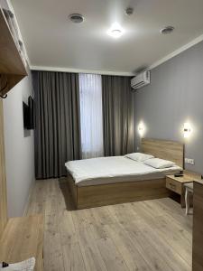 une chambre avec un lit et un bureau dans l'établissement Holiday house Bishkek, à Bishkek