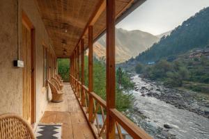 balcón con vistas al río y a las montañas en Living Good - A Himalayan Boutique Stay en Gushaini