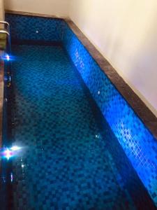 - une piscine revêtue de carrelage bleu dans l'établissement D'venza villa, à Tlekung