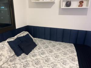 um quarto com uma cama com uma cabeceira azul em Studio na Orla em Salvador