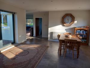 a kitchen with a table and chairs and a clock on the wall at The Bungalow in Coleford