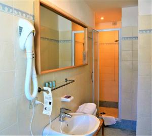 a bathroom with a shower and a sink with a blow dryer at Park Hotel Sancelso in Bellamonte