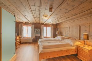 a bedroom with a bed and a wooden ceiling at Gasthaus & Hotel Berninahaus in Pontresina