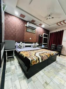 Hotel New Sun N Rock ( 1km from Nakki Lake ) في مونت ابو: غرفة نوم بسرير كبير في غرفة