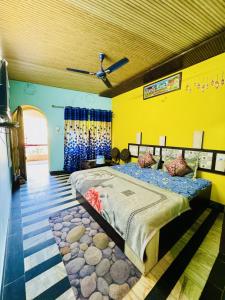 a bedroom with a large bed in a yellow room at Hotel New Sun N Rock ( 1km from Nakki Lake ) in Mount Ābu