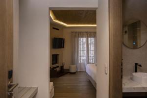 a bathroom with a bed and a sink and a mirror at Μikri Arktos Boutique Hotel in Dhimitsana