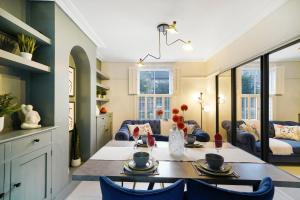 a kitchen and living room with a table and chairs at Lux 3 Bed London House - Garden in London