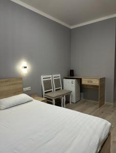 une chambre avec un lit, un bureau et une chaise dans l'établissement Holiday house Bishkek, à Bishkek