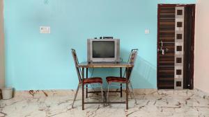einem Computer auf einem Tisch mit zwei Stühlen in der Unterkunft LD Guest House in Ayodhya