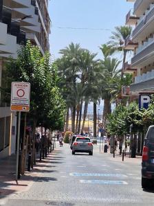 un coche conduciendo por una calle con palmeras en Old Town 1 st floor, near the beach, en Benidorm