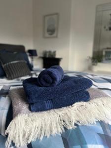 a pile of towels sitting on top of a bed at Village Escape in Messingham