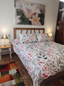 a bedroom with a bed with a floral bedspread at Granada Home Center in Granada