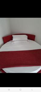 Bett mit rotem Kopfteil und weißer Bettwäsche in der Unterkunft Suite FURORE in Aversa