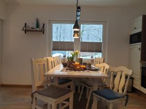 cocina con mesa con sillas y comedor en FeWo Winter in der Villa Waldrand mit zwei Balkonen, en Bad Wünnenberg