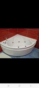 bañera blanca en una pared roja en Suite FURORE, en Aversa