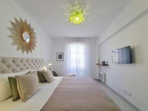 ein weißes Schlafzimmer mit einem großen Bett und einem Spiegel in der Unterkunft TLN-0011 - Magnifique appartement proche centre-ville in Six-Fours-les-Plages
