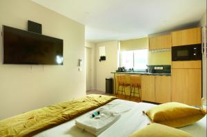 um quarto com uma cama, uma televisão e uma cozinha em Residence centre de Paris by Studio prestige em Paris