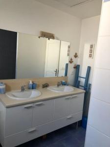 a bathroom with two sinks and a large mirror at Belle maison île de Ré avec piscine in Sainte-Marie-de-Ré