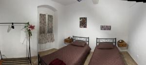 two beds in a room with white walls at Seal Home in Genoa