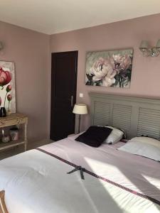 a bedroom with a large white bed with flowers on the wall at Belle maison île de Ré avec piscine in Sainte-Marie-de-Ré