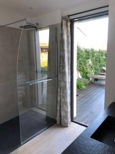 a glass shower in a bathroom with a sliding glass door at Belle maison île de Ré avec piscine in Sainte-Marie-de-Ré