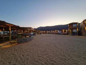 an empty street with a group of buildings on the beach at Life camp in Nuweiba