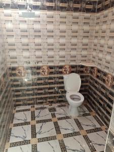 a toilet in a bathroom with a tiled floor at Life camp in Nuweiba