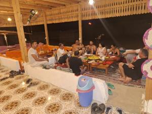 Un groupe de personnes assises autour d'une table dans l'établissement Life camp, à Nuweiba