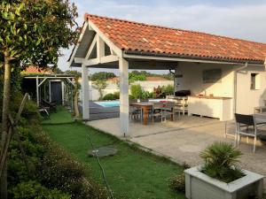 a white pavilion with a table and a table at Villa avec piscine 12 personnes #0606 in Capbreton