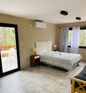 a bedroom with a bed and a table and windows at Bosque Libertad Loft in Mar Azul