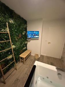 La salle de bains est pourvue d'un mur vert et d'une baignoire. dans l'établissement MarbleMood Spa, à Obernai