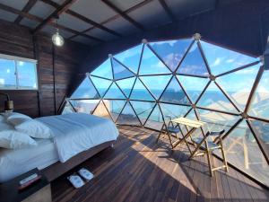 a bedroom with a bed and a large window at 321 Surprise Beach house and Glamping in Providencia