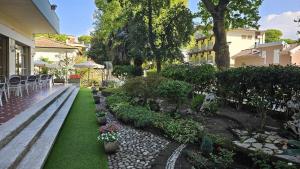 a garden with a bench and chairs and flowers at Hotel Rosa in Cervia