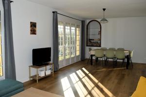 濱海呂克的住宿－Les 7 lutins - Maison avec jardin, wifi, parking，客厅配有桌椅和电视。