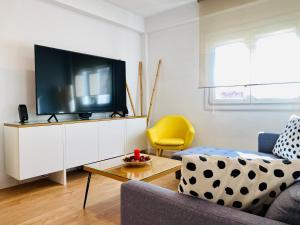 a living room with a couch and a tv at Apartamento HC13 - PUERTA PURCHENA in Almería +20 photos